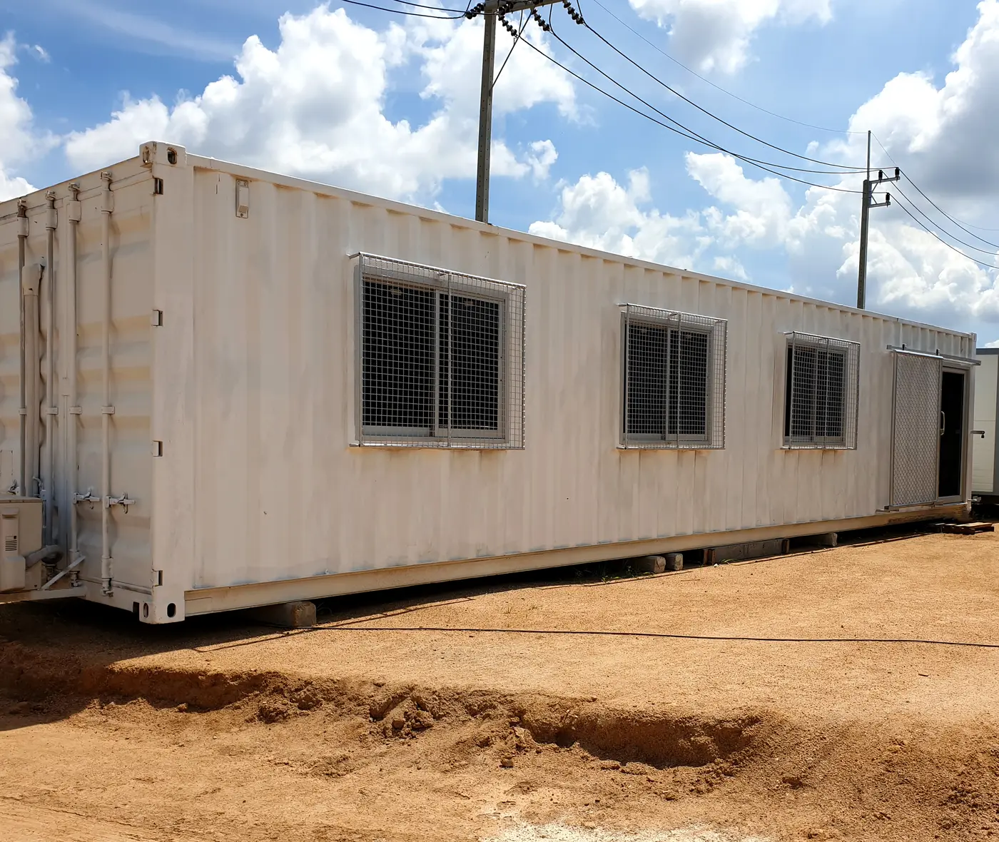 A container site office standing on a graded dirt lot