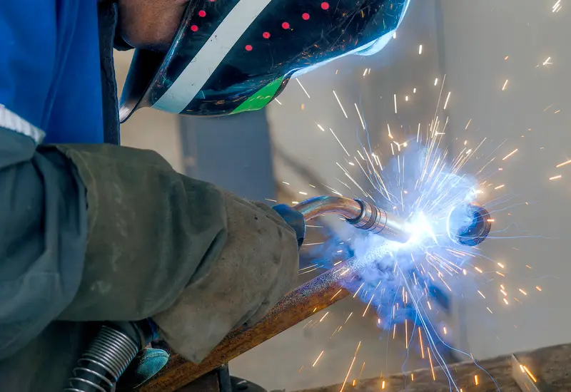 A welder cutting a container modification, sparks flying